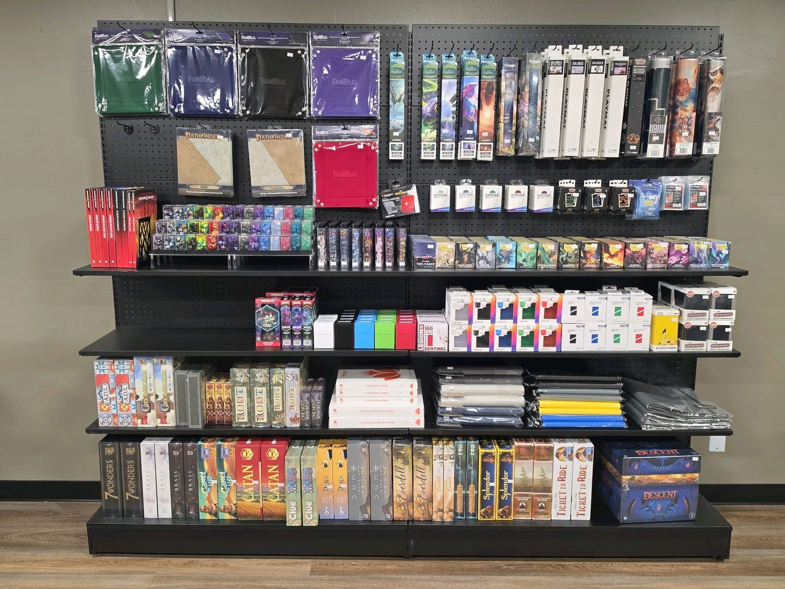 A wall of shelving stocked with card sleeves, deck boxes, binders and playmats.