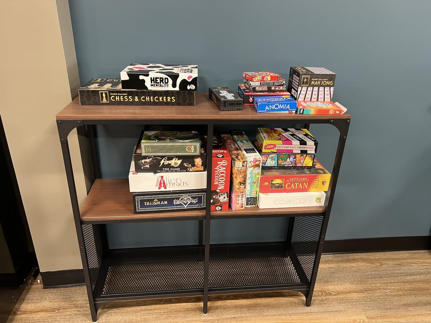 A two-tier shelf of board games including Catan and Chess & Checkers.