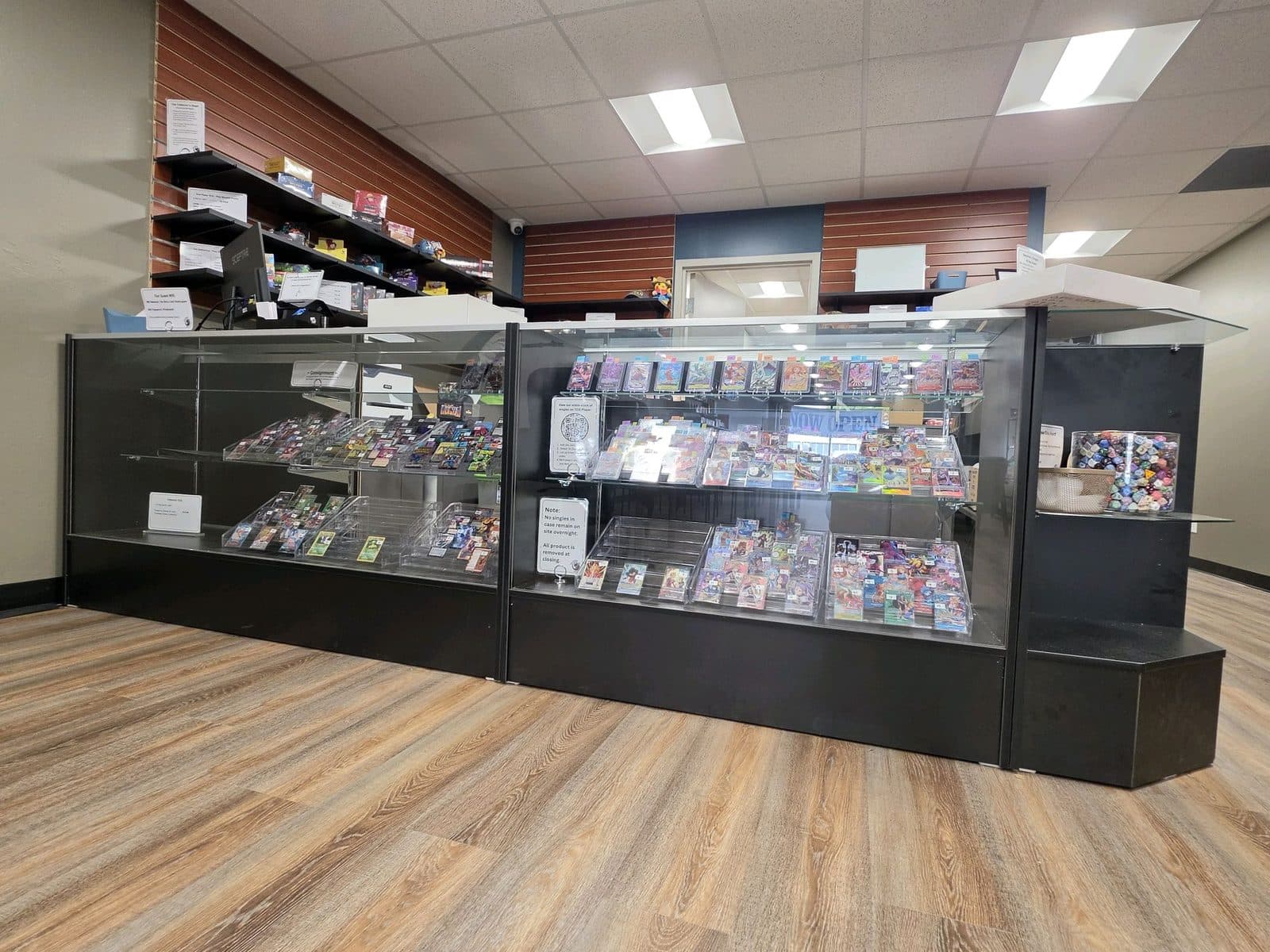 A long glass display counter along the wall, filled with sealed product and singles.