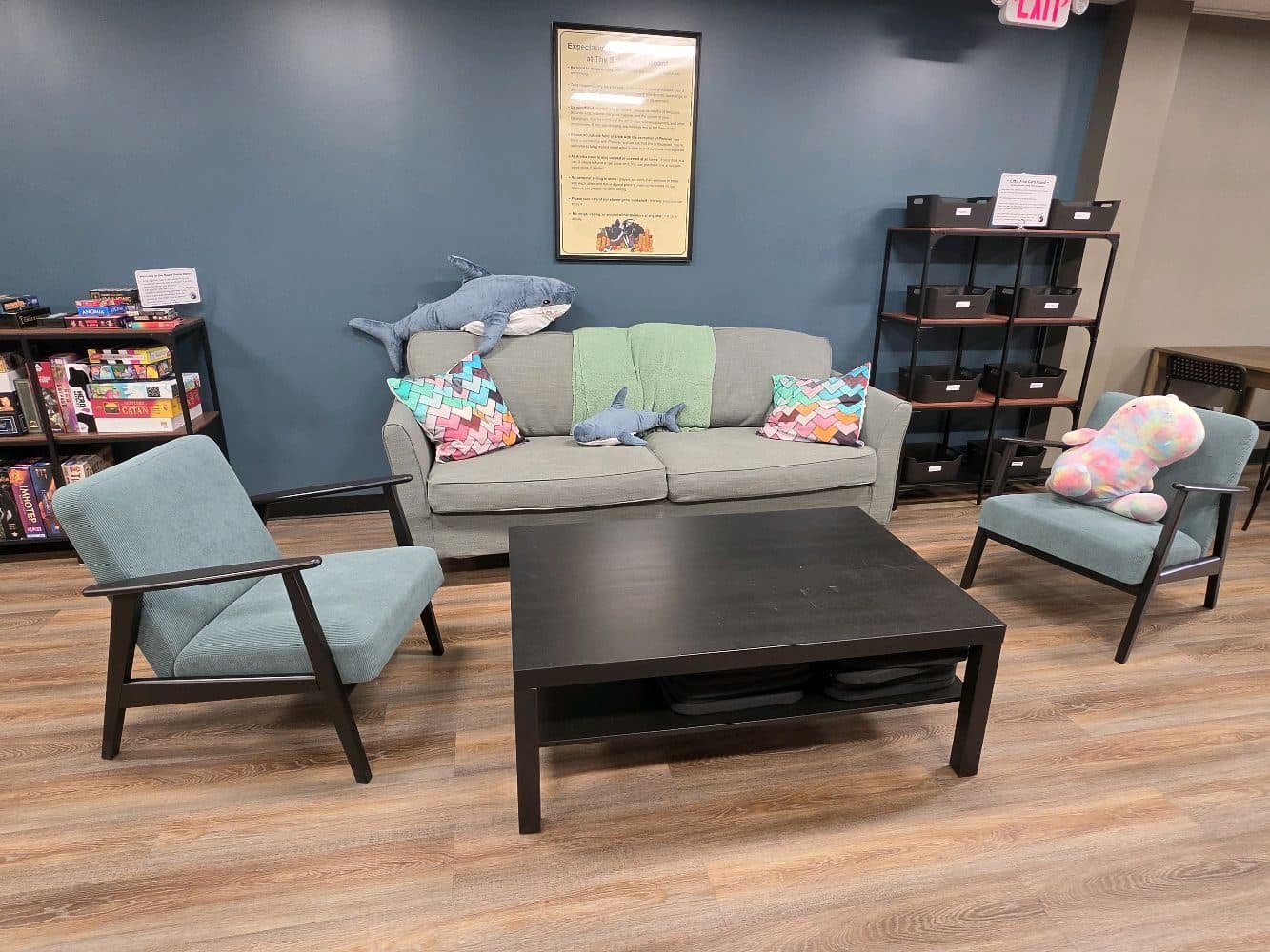 The lounge: a sofa, two armchairs and a low coffee table, with shelving behind.