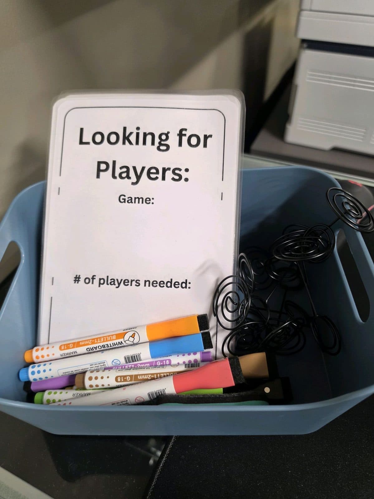 A “Looking for players” bin holding blank sign-up cards and dry-erase markers.