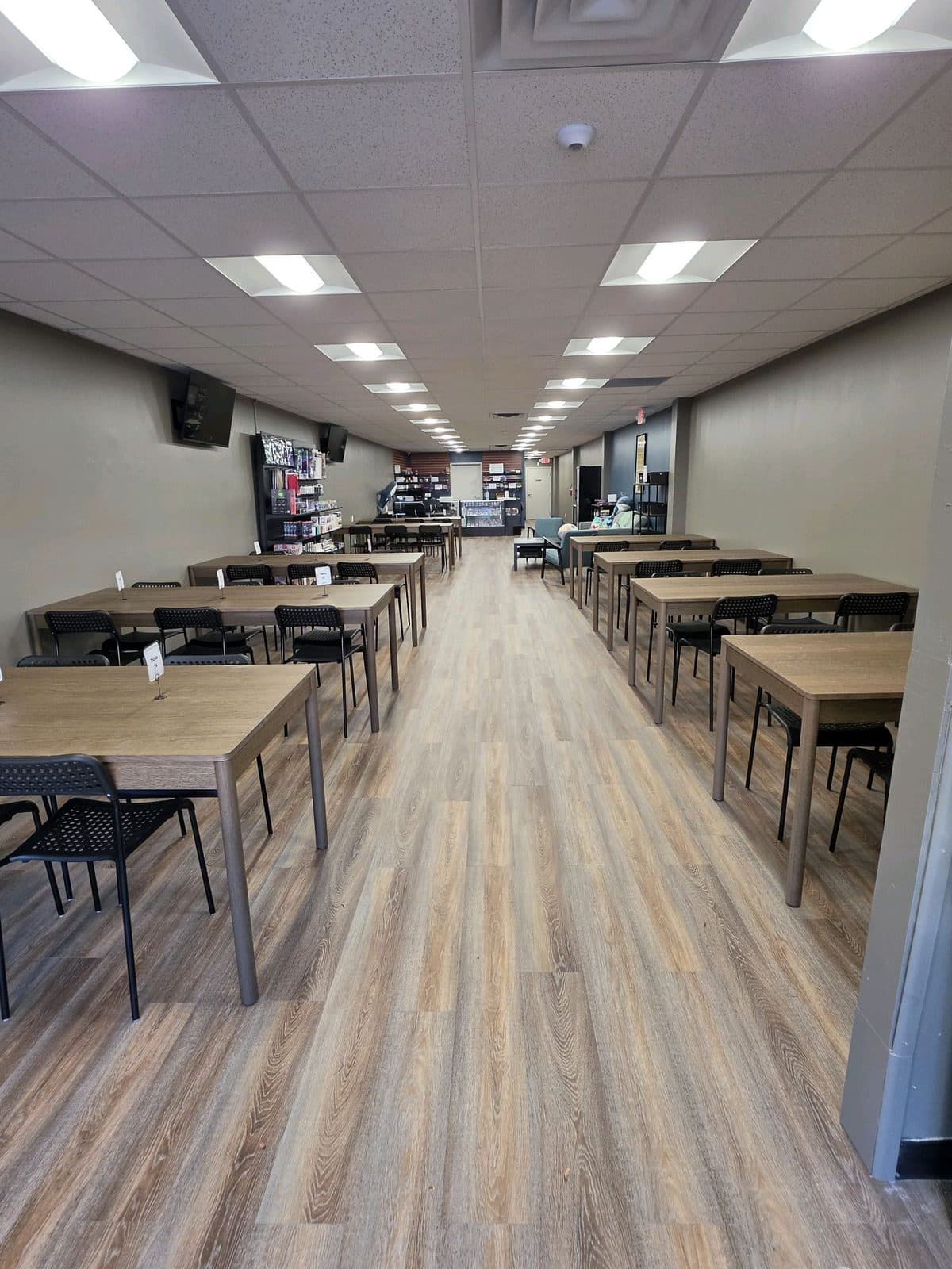 The play space seen from the door: rows of tall tables and stools running the length of the room.